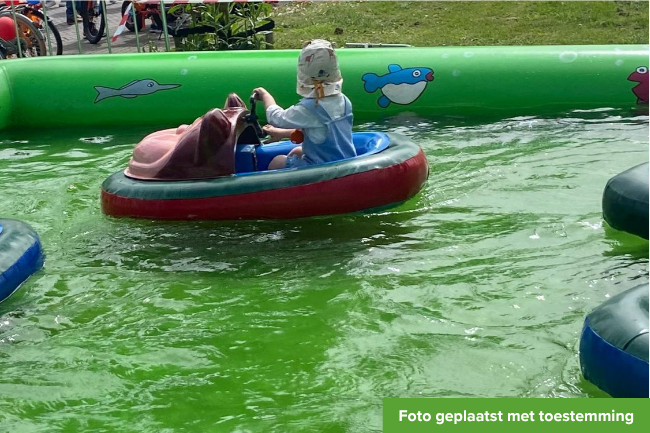 Jongetje van drie jaar vaart in een speelbootje.