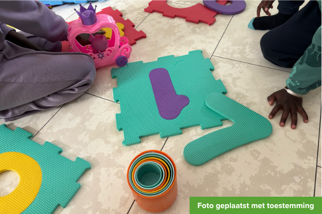 Meisje en jongen spelen op de grond.