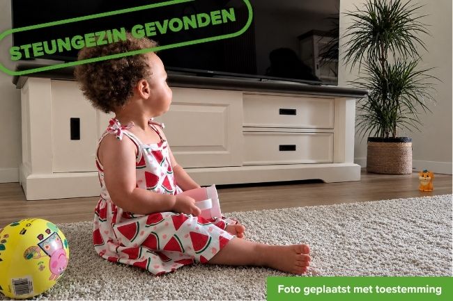 Klein meisje zit op een kleed