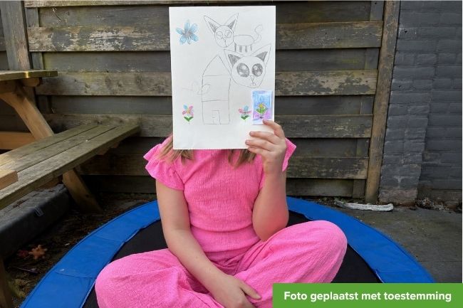 afbeelding met meisje zittende op trampoline met een tekening voor haar gezicht